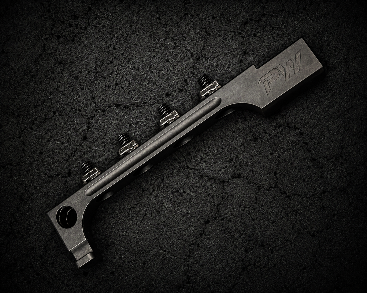 PsychWard Labs Harpoon M-LOK AK bayonet adapter with four mounting screws on a dark concrete background